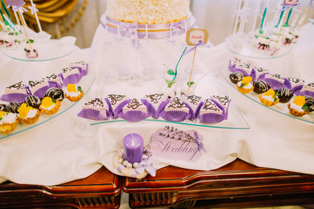 婚礼甜点吧。与婚礼标志和蜡烛装饰在桌子上的甜饼近距离查看