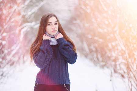 一个年轻的女孩在一个冬天公园散步。圣诞假期在 t