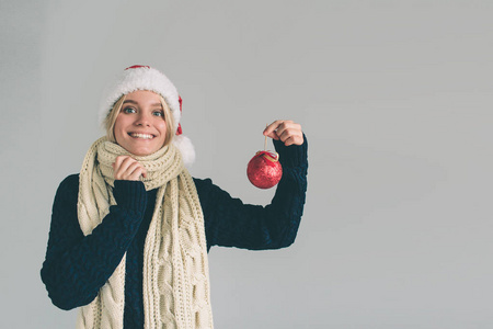 大红色圣诞球手在妇女。女孩穿着毛衣, 圣诞帽和围巾工作室拍摄
