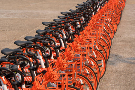 在街上停车的一排橙色自行车供公众使用