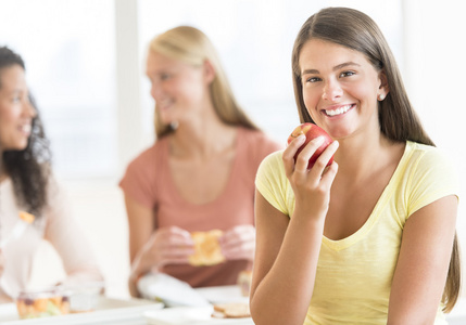 十几岁的学生在大学食堂吃苹果