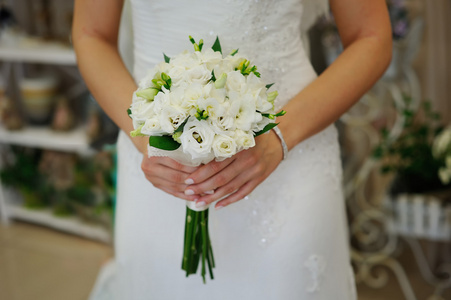 新娘举行白色婚礼花束的玫瑰