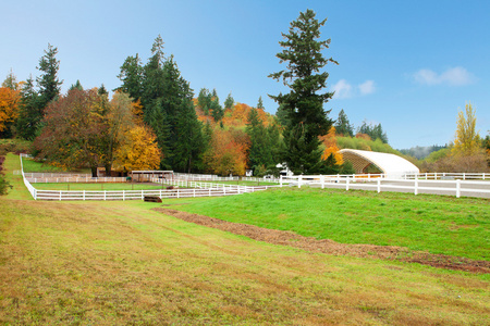 马农场与白色的篱笆和秋天多彩的树叶