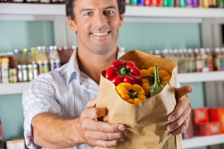 男性客户在纸袋中显示 bellpeppers