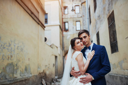 一对幸福情侣的婚礼肖像。站在旧城的街道上亲吻