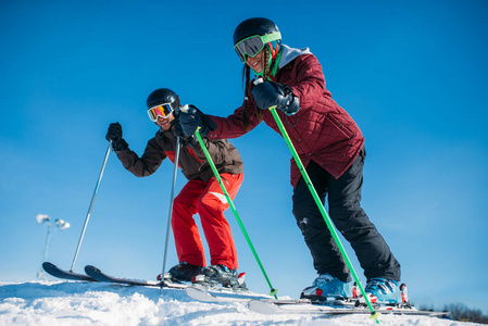 男性和女性滑雪者从山, 冬天活跃体育赛跑