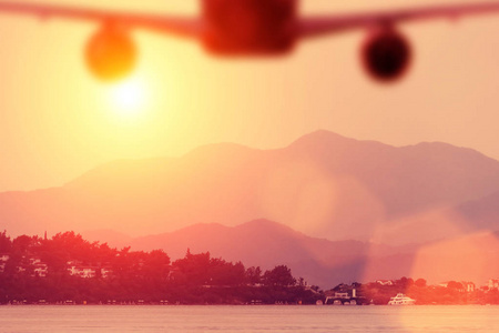 日落时分飞往海滩的飞机剪影