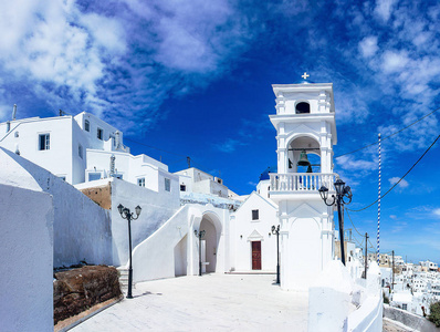 美丽的白色教堂与钟声和蓝色圆顶在 Amerofigli, 圣托里尼, 希腊