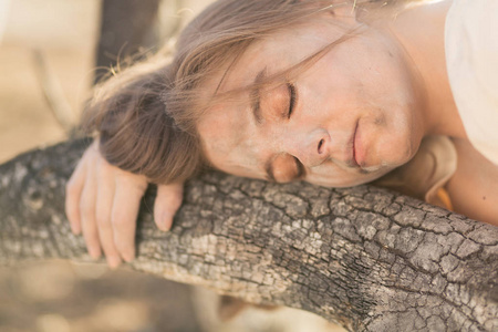 关闭年轻的混合种族妇女在白色礼服躺在被野火烧毁, 而覆盖在灰烬中的树木