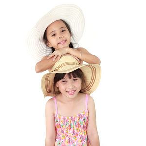 两个美丽快乐的小亚洲女孩用稻草