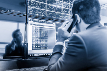股票交易商看电脑屏幕上的市场数据