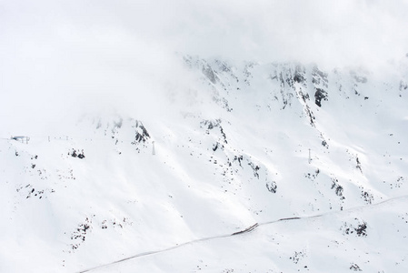 山风景。雾和云在顶部。雪覆盖的斜坡