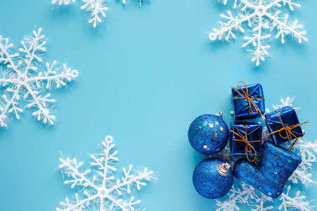 圣诞礼物盒, 闪光球, 靴子和雪花装饰在蓝色背景圣诞节和假期的概念