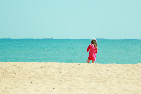 欧洲在明亮的衣服的小女孩玩，在夏季主题海上玩得开心