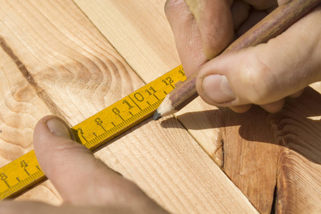 木匠测量距离用一个措施和标记与木匠的铅笔