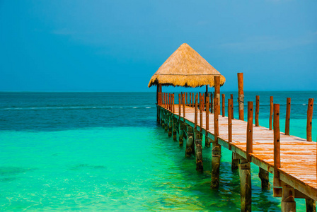 海滩上的码头和木制凉亭。热带景观与跳船 海, 沙子, 岩石, 波浪, 绿松石水。墨西哥坎昆