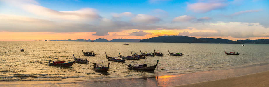 夏季日在泰国奥南海滩日落时传统长尾船全景