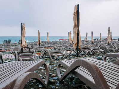 黑海卵石海滩与太阳床和雨伞在坏