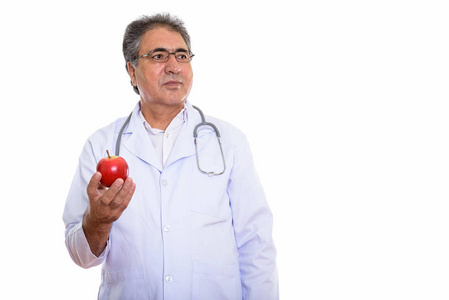 工作室拍摄的资深波斯人医生持有红苹果, 而思考