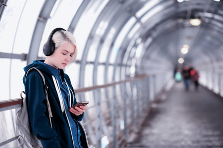 在地铁里大耳机听音乐的年轻学生