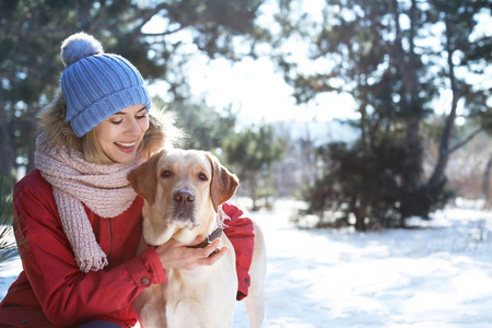 冬天的时候在户外的女人和可爱的狗。宠物与主人之间的友谊