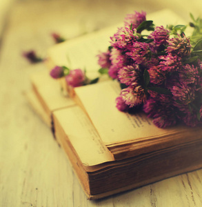 在木桌上打开的书鲜花的花束