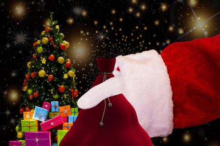 圣诞节背景圣诞老人手持他的背部与礼物和星星的背景