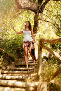 美丽的年轻女子享受漫步在松树林在夏天