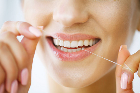 牙齿护理。美丽的微笑的女人牙线健康的白牙齿