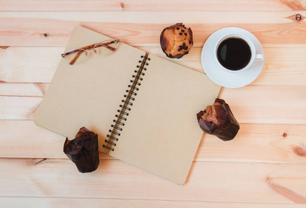 杯咖啡, 空笔记本和松饼在木质背景下