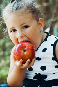 在吃苹果时关闭一个甜美的小女孩的肖像