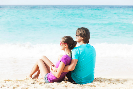 漂亮年轻夫妇坐在和上海滩很开心
