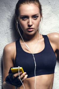 年轻的健身女人听音乐