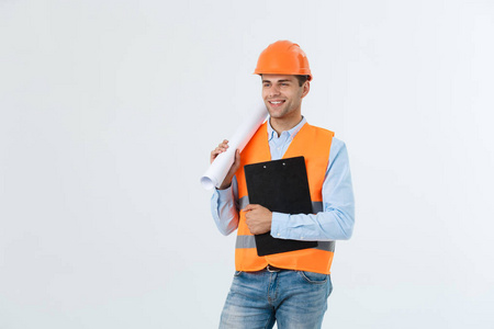 半身人像的年轻笑得帅帅建筑师工程师在橙色头盔与蓝图望着孤立在白色的背景下，copyspace 的相机合影