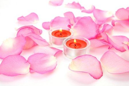 粉红色的玫瑰和燃烧蜡烛的花瓣