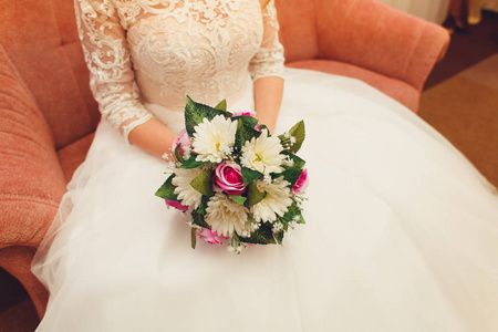 美丽的新娘穿着白色婚纱，拿着花束