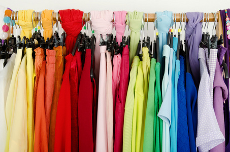 紧靠颜色协调在存储区中的衣架上的衣服