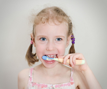 小女孩用牙刷刷牙