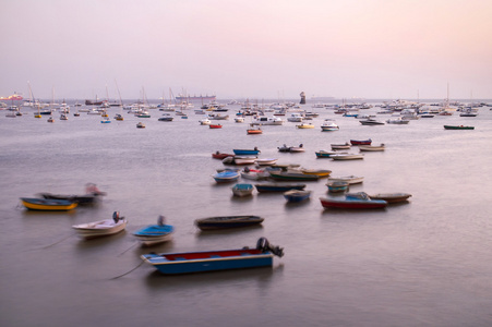 美丽的许多小船在波浪在印度孟买的黄昏景色