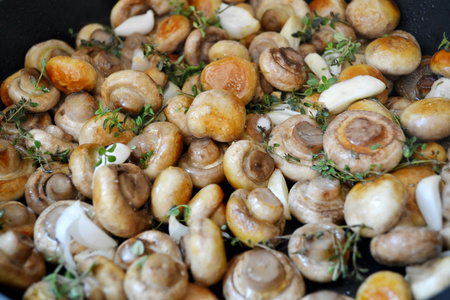 与百里香和大蒜在平底锅里的烤的蘑菇香菇