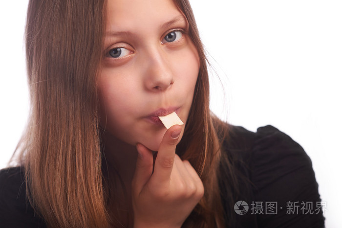 十几岁的女孩在白色背景上吃泡泡糖