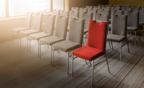 在空会议室里, 一把与其他不同的红色椅子