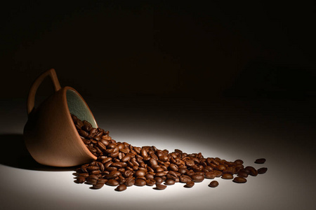 咖啡豆咖啡杯在黑暗背景下的聚光灯下