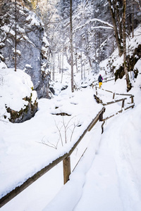 年轻女子徒步穿越雪山峡谷 Baerenschuetzklamm 冰冻瀑布