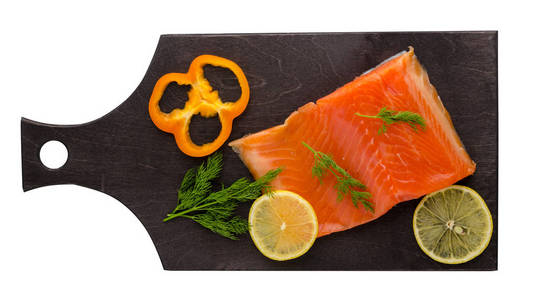 红鱼鳟鱼鱼片在盘子上。鱼鳟鱼在白色背景下分离。有莳萝, 柠檬和胡椒的鳟鱼