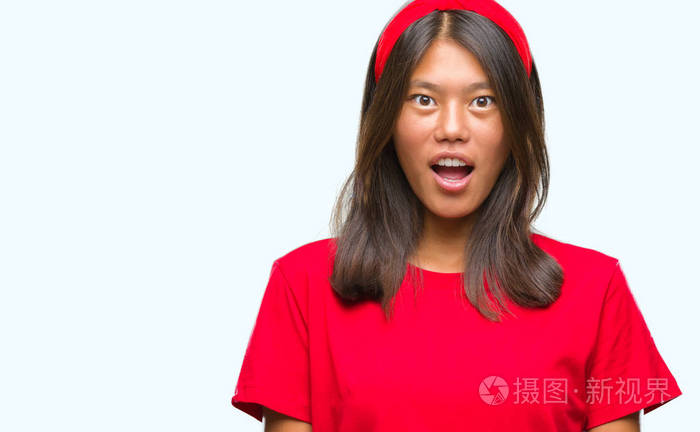 在孤立背景下的年轻亚裔妇女害怕和震惊与惊喜的表情