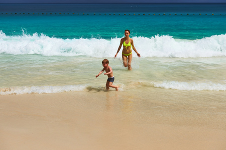 母亲和两岁的男孩在沙滩上玩