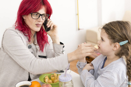 红头发的妈妈在给孩子喂奶的时候打电话