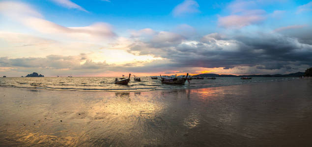 夏季日在泰国奥南海滩日落时传统长尾船全景