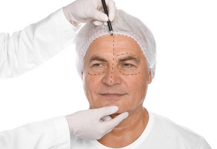 白色背景整容手术前的医生标记老人脸